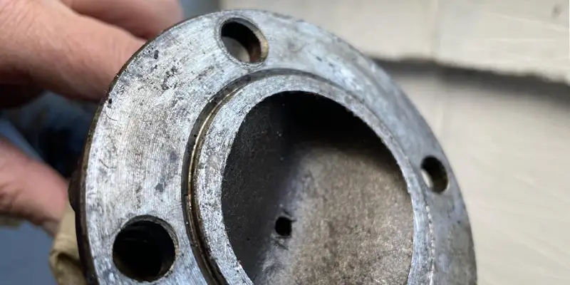 worn driveshaft flange with damaged bolt holes and center bore
